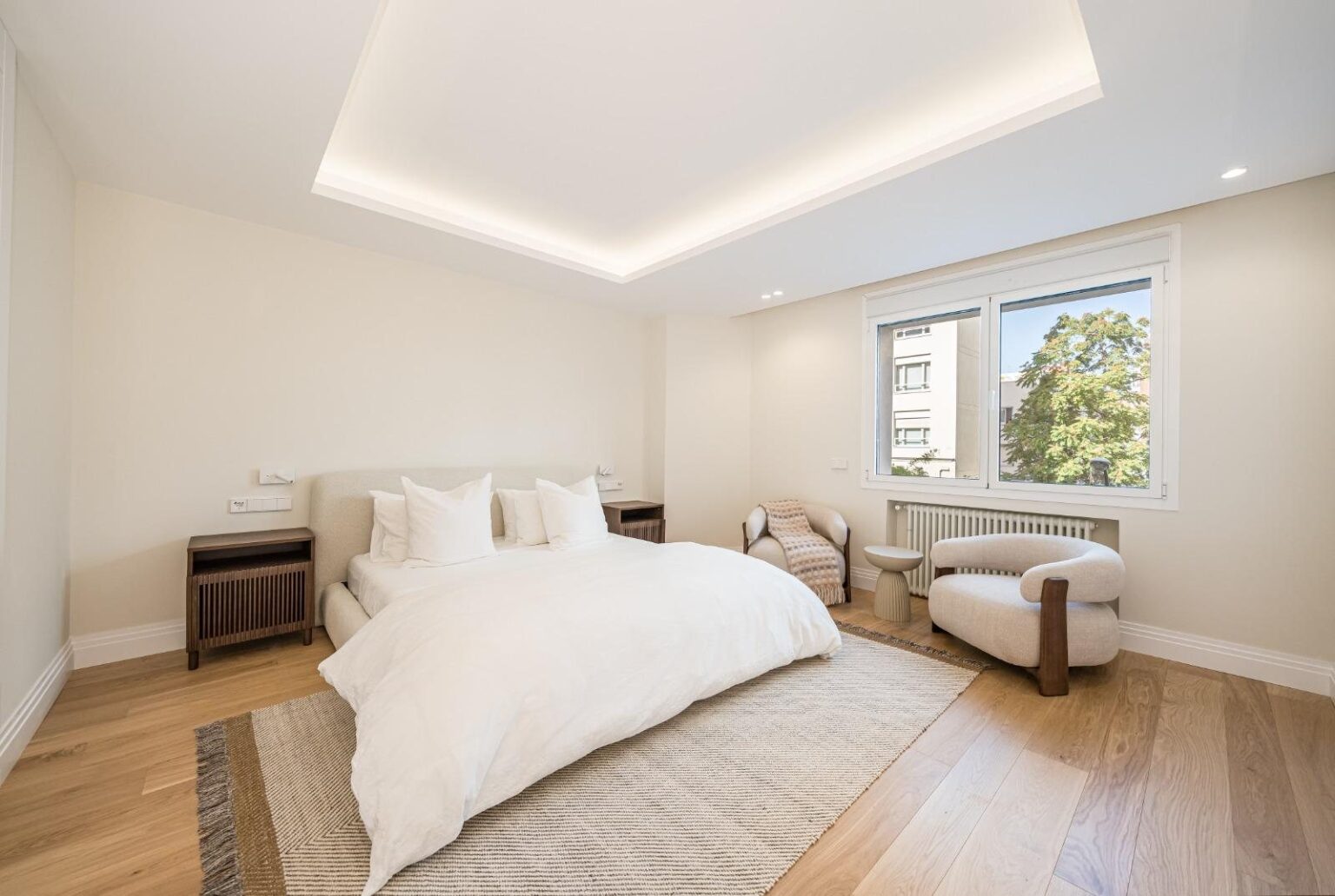 Dormitorio con zona de estar junto a la ventana, vivienda en Almagro, Madrid