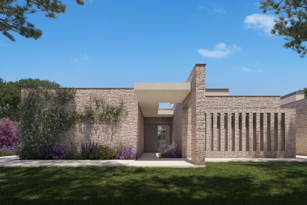 Villa de una planta en Boadilla, con la fachada de piedra y el jardín delante